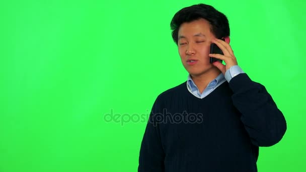Asiático hombre habla en un teléfono inteligente con una sonrisa — Vídeo de stock
