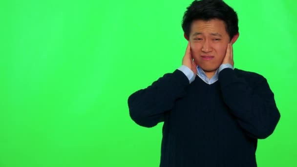 Człowieka obejmuje jego uszy i grymasy przeciwko głośny dźwięk — Wideo stockowe