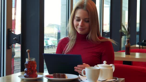 Woman in a cafe and works on a tablet — Stock Video