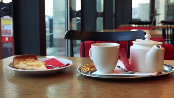 Un postre y un juego de té en una mesa en un café — Vídeo de stock