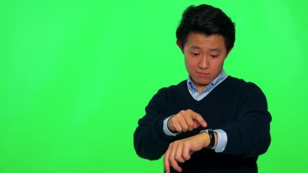 Hombre mira a la cámara y toca su reloj de pulsera — Vídeos de Stock