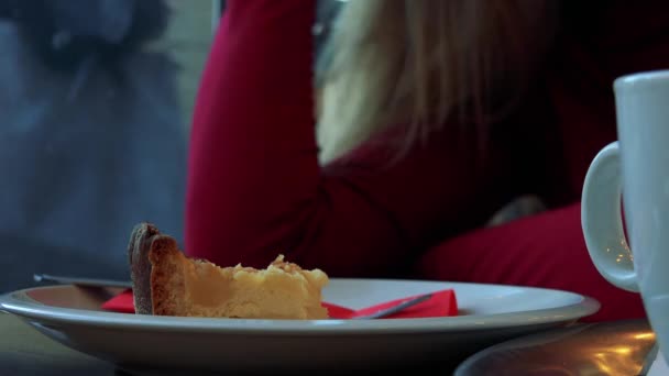 Пиріг в кафе і жінка грає з волоссям — стокове відео