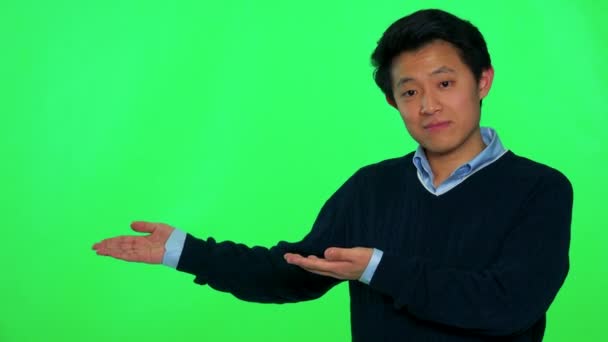 Ein junger asiatischer Mann präsentiert etwas — Stockvideo