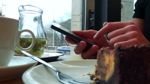 Человек в кафе и работает на смартфоне — стоковое видео