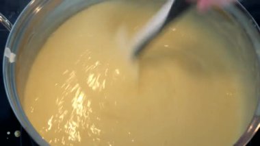 Bir kadın akıntısı krem bir kapta bir spatula ile kıpırdanırken 
