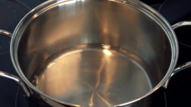 Bir kadın bir ölçüm kabı ile bir pota su dökülen 