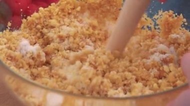 Bir kadın bir kapta şekerli kurabiye kırıntısı karışımları 