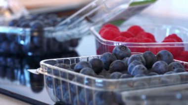 Yaban mersini ve küçük plastik kutular içinde ahududu 