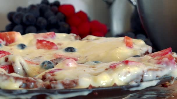A bottom of a cake base with cream and fruits — Stock Video