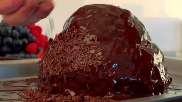 Een vrouw hagelslag geraspte chocolade op een taart — Stockvideo