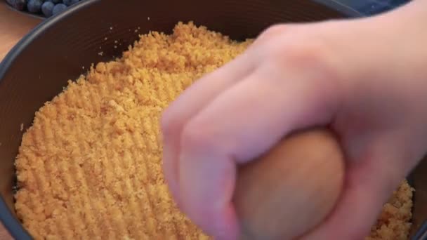 Женщина нажимает крошки печенья на дне формы выпечки — стоковое видео
