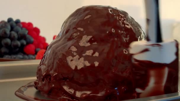 Revêtement au chocolat est réparti sur un gâteau sur un plateau — Video