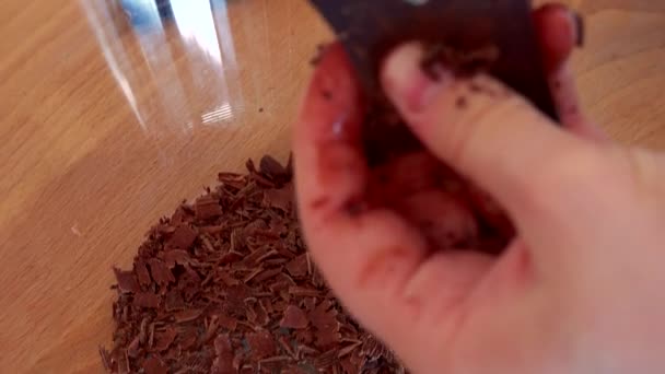 Женщина натерла плитку тёмного шоколада — стоковое видео