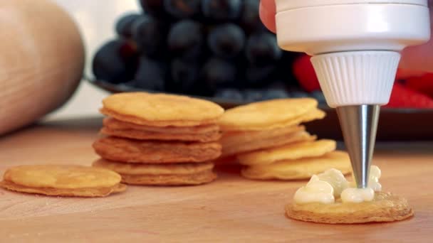 A woman makes a dessert out of pastry rounds and cream — Stock Video