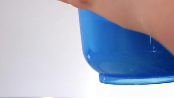 Een vrouw giet de melk in een plastic meten kruik — Stockvideo