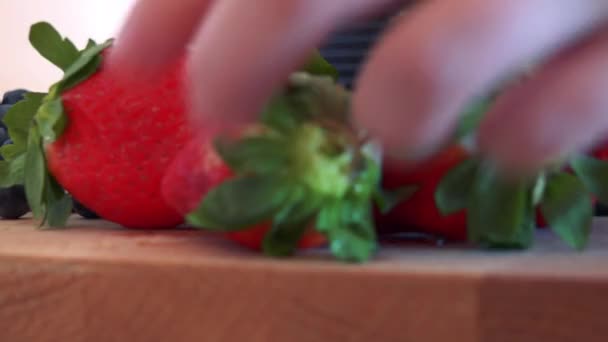 Uma mulher coloca morangos em um balcão de cozinha — Vídeo de Stock