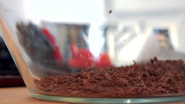 Migas de chocolate rallado caen en un tazón — Vídeo de stock