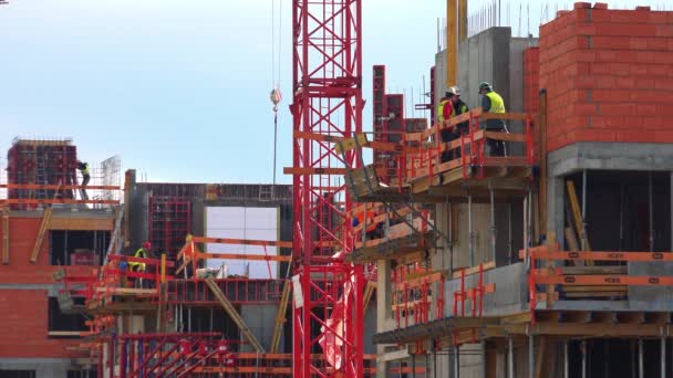 Los trabajadores trabajan en la construcción de edificios — Vídeos de Stock