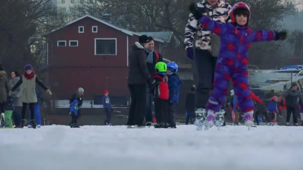 Діти і дорослі льоду кататися на ковзанах на замерзлому річки — стокове відео