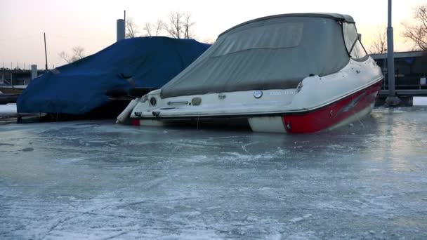Човни, припарковані біля причалу на замерзлій річці — стокове відео