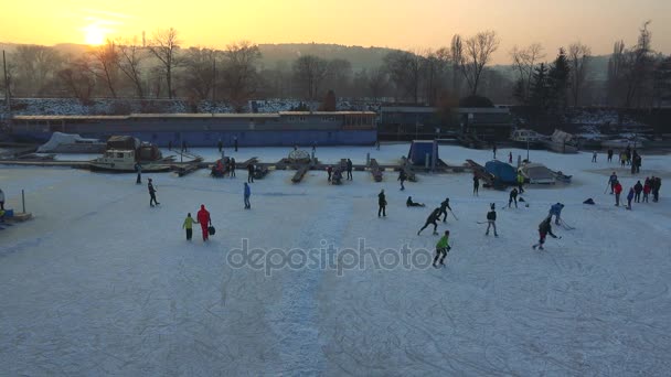 La gente gioca a hockey su un fiume ghiacciato — Video Stock