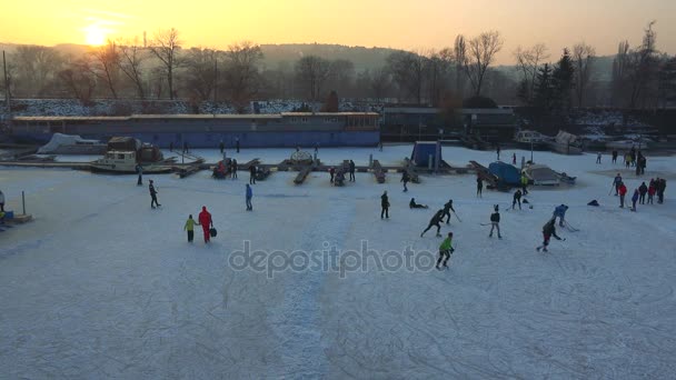 Lidé hrají hokej na zamrzlou řeku 