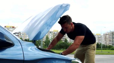 adam görünüyor ve araba motoru denetler 