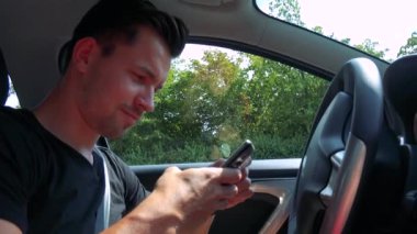 adam bir araba ve Smartphone'da yazarak sürücüler