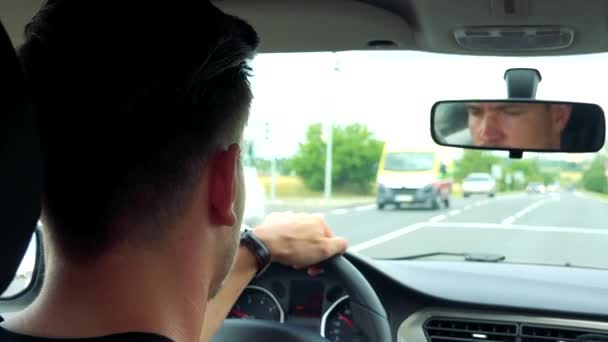 Красивый мужчина управляет машиной на дороге — стоковое видео