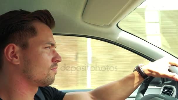 Человек водит машину по дороге в городе — стоковое видео