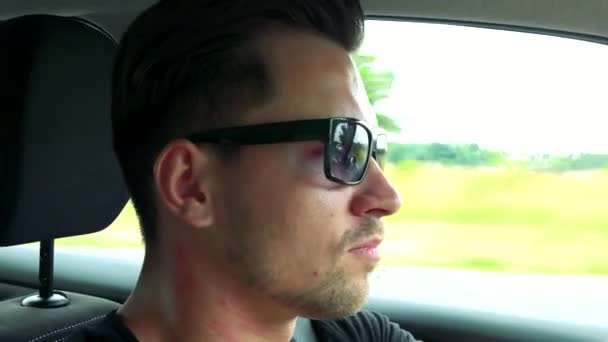 Man drives a car with sunglasses on the road — Stock Video