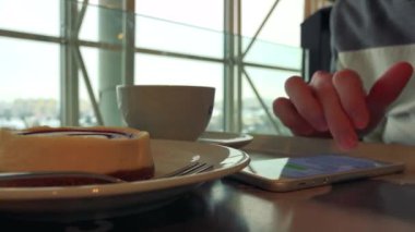 Bir adam bir kafe ve çalışan bir smartphone cep telefonu ile kahvaltı ile 