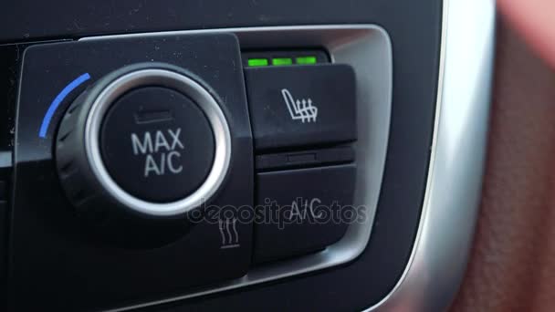 Мужчина нажимает кнопку "Heated Seat High" на приборной панели в машине — стоковое видео