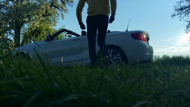 Um homem caminha para um luxuoso carro sem teto — Vídeo de Stock