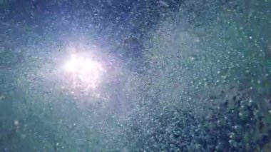 su yüzeyi kabarcıklar ve gökyüzünde güneş 