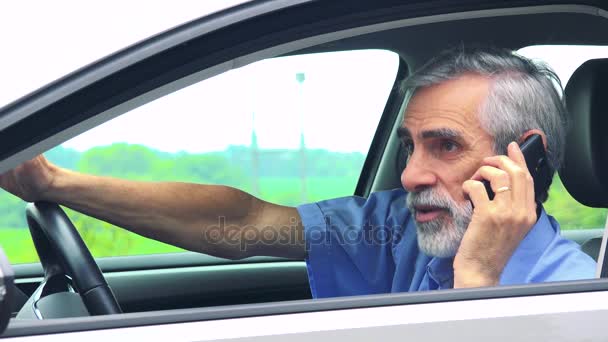 资深男子坐在汽车和电话与智能手机特写镜头从侧面农村的背景 — 图库视频影像