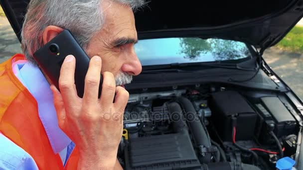 Senior Trägt Warnweste Und Telefoniert Mit Smartphone Neben Offener Motorhaube — Stockvideo