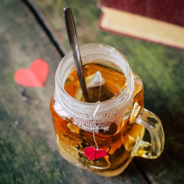 Bir tablo, kitap ve kalpleri bir kupa çay