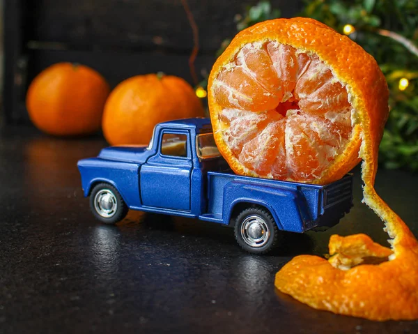 tangerine is transporting a toy car,new Year mood (Christmas story, citrus in the trunk auto) menu concept. food background. top view. copy space