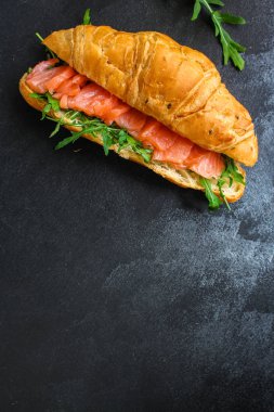 balık sandviçi ve yeşillikler, Smorrebrod (tuzlanmış somon, kruvasan, ekmek, roka ve diğer malzemeler) menü konsepti. Yemek geçmişi. Üst Manzara. Boşluğu kopyala