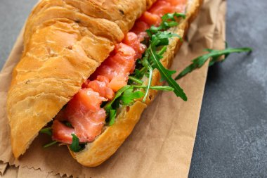 balık sandviçi ve yeşillikler, Smorrebrod (tuzlanmış somon, kruvasan, ekmek, roka ve diğer malzemeler) menü konsepti. Yemek geçmişi. Üst Manzara. Boşluğu kopyala