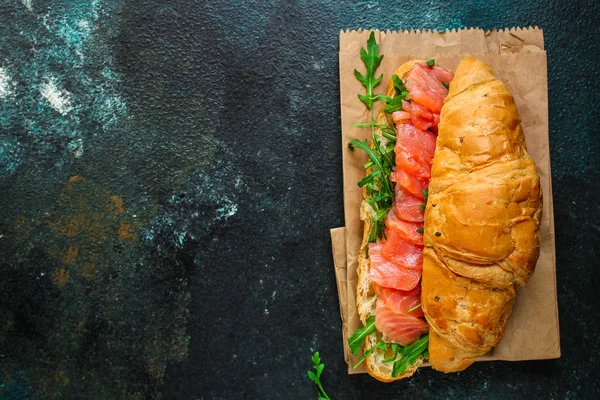 魚のサンドイッチとグリーン スモアブロード クロワッサン アルグラなどの食材 メニューのコンセプト 食べ物の背景最上階だコピースペース — ストック写真