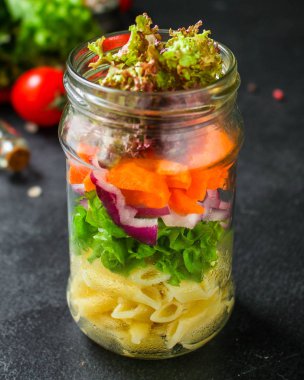 Kavanozda sağlıklı salata (sebzeli makarna salatası) menü kavramı. Yemek geçmişi. Üst Manzara. Boşluğu kopyala