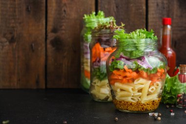 Kavanozda sağlıklı salata (sebzeli makarna salatası) menü kavramı. Yemek geçmişi. Üst Manzara. Boşluğu kopyala