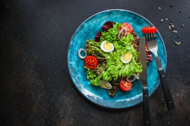 Sağlıklı salata sebzeleri, bıldırcın yumurtaları (domates, marul ve diğer malzemeler) menü konsepti. Yemek geçmişi. Üst Manzara. Boşluğu kopyala