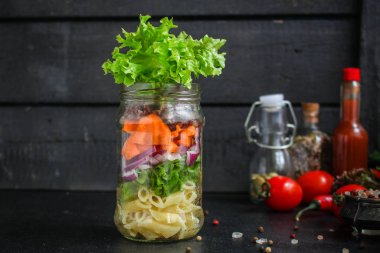 Kavanozda sağlıklı salata (sebzeli makarna salatası) menü kavramı. Yemek geçmişi. Üst Manzara. Boşluğu kopyala