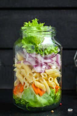 Kavanozda sağlıklı salata (sebzeli makarna salatası) menü kavramı. Yemek geçmişi. Üst Manzara. Boşluğu kopyala