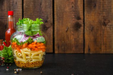 Kavanozda sağlıklı salata (sebzeli makarna salatası) menü kavramı. Yemek geçmişi. Üst Manzara. Boşluğu kopyala