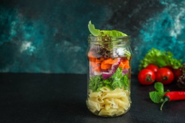 Kavanozda sağlıklı salata (sebzeli makarna salatası) menü kavramı. Yemek geçmişi. Üst Manzara. Boşluğu kopyala