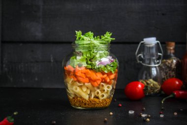 Kavanozda sağlıklı salata (sebzeli makarna salatası) menü kavramı. Yemek geçmişi. Üst Manzara. Boşluğu kopyala